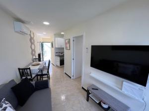sala de estar con TV de pantalla plana grande en Sunrise Apartment - Playa del Inglés, en Playa del Inglés