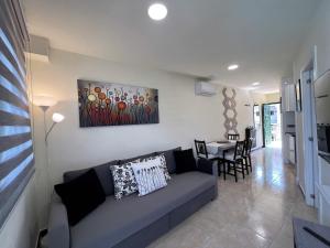 プラヤ・デル・イングレスにあるSunrise Apartment - Playa del Inglésのリビングルーム(ソファ、テーブル付)