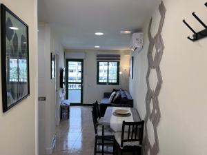プラヤ・デル・イングレスにあるSunrise Apartment - Playa del Inglésのダイニングルーム、リビングルーム(テーブル、椅子付)