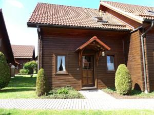 a small house with a wooden door in a yard at Ferienhaus Nr 23, Typ A, Ferienanlage Blauvogel, Hasselfelde, Harz in Hasselfelde