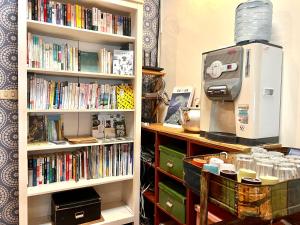 a book shelf filled with books next to a bookilit at Gift Box Hostel in Chishang