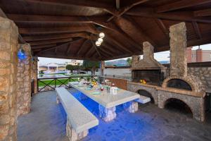 a patio with a table and a stone fireplace at Marble Pool Villa in Pastida