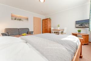 ein Schlafzimmer mit einem Bett, einem Sofa und einem Tisch in der Unterkunft Fahrenkrug Wohnung 4 in Scharbeutz