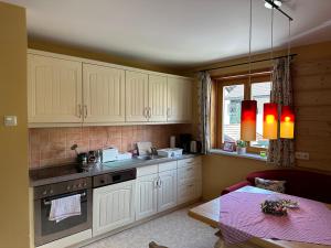 a kitchen with white cabinets and a table and a window at Maier Chalet in Bayerisch Eisenstein