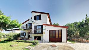 a white house with a red roof and a garage at Apartment Lungera in Pula