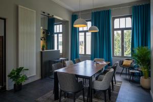 una sala da pranzo con tende blu e tavolo e sedie di Havenhuis Brugge a Bruges