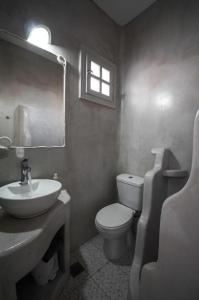 baño con lavabo y aseo y ventana en Anerousses, en Adamas