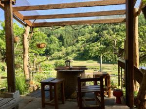 a porch with a table and chairs and a view of a field at Guesthouse In Lak'ech - Vacation STAY 03558v in Kami-ikusaka