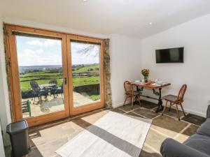 a living room with a view of a table and chairs at The Barn at Crow Hill Shaw Farm in Sowerby Bridge