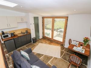 a living room with a couch and a kitchen at The Barn at Crow Hill Shaw Farm in Sowerby Bridge