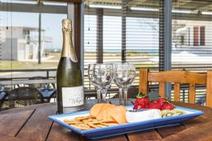 butelkę wina oraz talerz sera i truskawek w obiekcie Beach Break - Family Accommodation with Ocean Views w mieście Lancelin