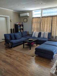 ein Wohnzimmer mit einem blauen Sofa und einem Tisch in der Unterkunft Blueshack - Walking Distance To Foreshore in Guilderton