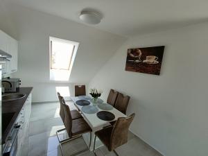 a kitchen with a dining room table and chairs at Flower Apartman 6 