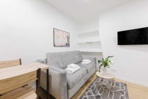 ein Wohnzimmer mit einem Sofa und einem Flachbild-TV in der Unterkunft Cosy Studio 2P MARX DORMOY in Paris