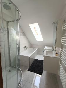 een badkamer met een douche, een wastafel en een bad bij Flower Apartman 6 