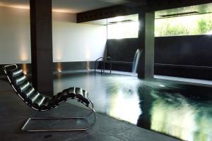 a chair in a room with a swimming pool at Victoria Palace Hotel in Cattolica