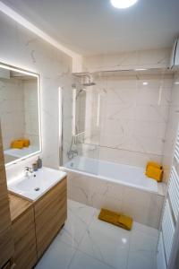 a white bathroom with a tub and a sink at Po City Newly Built Apartment in Prešov