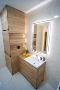 a bathroom with a sink and a mirror at Po City Newly Built Apartment in Prešov