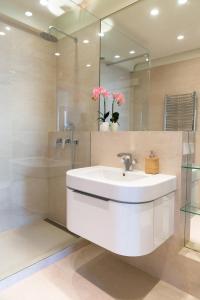 La salle de bains est pourvue d'un lavabo blanc et d'une douche. dans l'établissement Old Town Heart XI - Mokotowska, à Varsovie