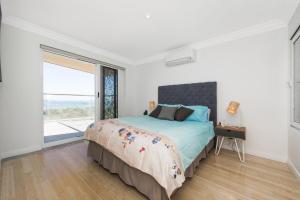 sypialnia z łóżkiem i dużym oknem w obiekcie Oceans View - Luxury Apartment with ocean views w mieście Lancelin