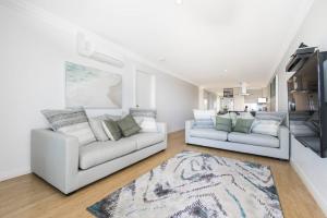 uma sala de estar com dois sofás brancos e um tapete em Oceans Waves - Luxury Apartment with ocean views em Lancelin