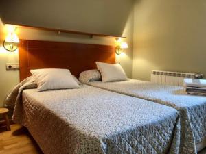 1 dormitorio con 2 camas y almohadas blancas en Casa Lauré II - PANTICOSA, en Panticosa