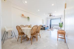 a dining room and living room with a table and chairs at PortDickson Cozy Muji Home 10Pax3BR 1min to beach in Port Dickson