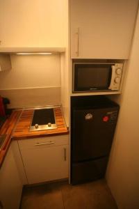 una pequeña cocina con nevera negra y microondas en Coqueto Estudio en Malasaña, en Madrid