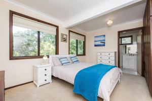 a bedroom with a bed with a blue blanket at Relax Moore - Close to Beach in Guilderton