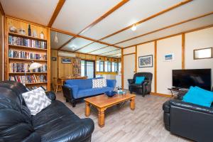 ein Wohnzimmer mit Sofas, einem TV und einem Tisch in der Unterkunft Sea Breeze - Perfect house for the family in Lancelin