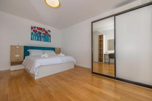 - une chambre avec un lit et un grand miroir dans l'établissement Villa Veronika Apartments, à Crikvenica