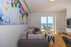 a living room with a couch and a painting on the wall at Villa Veronika Apartments in Crikvenica