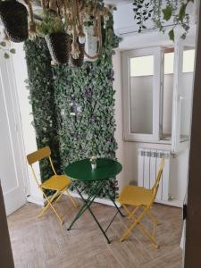 a table and chairs in a room with a green wall at B&B Angelica Apartment in Benevento