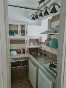 una cocina con armarios blancos y fregadero en B&B Angelica Apartment, en Benevento