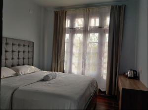sypialnia z łóżkiem i dużym oknem w obiekcie Gracia Locus- Home Comfort w Dimapur