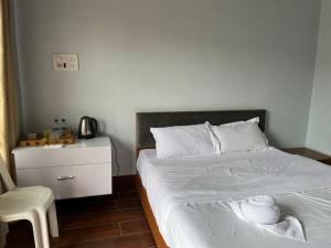sypialnia z łóżkiem z krzesłem i stolikiem nocnym w obiekcie Gracia Locus- Home Comfort w Dimapur