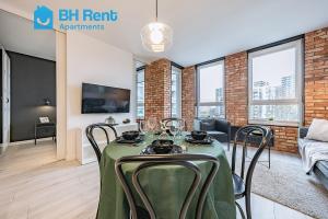 comedor con mesa verde y sillas en BH Rent Apartments, Gdańsk Krynicka 2, SoHo en Gdansk