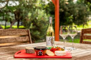 een fles wijn en twee glazen op een tafel bij Waves And Moore - Beautifully presented home in Guilderton