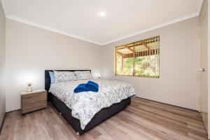 een witte slaapkamer met een bed en een raam bij Waves And Moore - Beautifully presented home in Guilderton