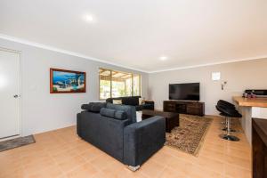 a living room with a couch and a tv at Waves And Moore - Beautifully presented home in Guilderton