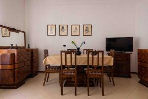 jadalnia ze stołem, krzesłami i telewizorem w obiekcie L'anfiteatro w mieście Vercelli