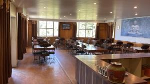 a room with tables and chairs in a restaurant at Exquisite Luxurious Presidential Stay- Pure Veg in Dalhousie