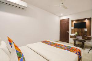 Habitación de hotel con cama y escritorio en FabHotel Usha Continental, en Muthiganj