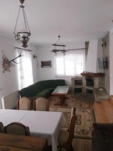 a living room with a green couch and a table at Șoaptele pădurii & Căsuța din pădure in Suceviţa