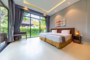 a bedroom with a bed and a large window at Emerald Garden Retreat in Phú Quốc