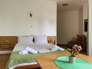 a bedroom with a bed with two pillows and a table at Хотел ЗОНАРИТА in Primorsko