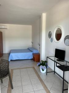 Schlafzimmer mit einem Bett, einem Tisch und einem TV in der Unterkunft Residence Paradise in Peschici