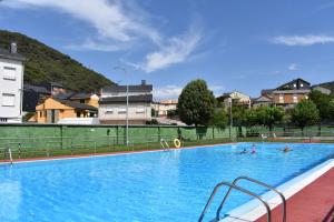 a large swimming pool with people in the water at Vivienda de Uso Turístico ABELLA in Matarrosa del Sil
