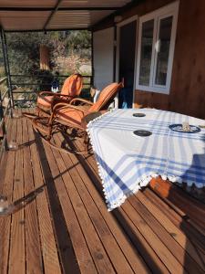 una mesa y sillas en una terraza de madera en Field Of Possibilites - Kayakoy Retreat, en Kayakoy