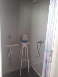 een badkamer met een kruk, een wastafel en een douche bij Field Of Possibilites - Kayakoy Retreat in Kayakoy